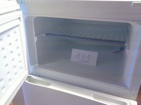 An empty freezer with a paper says 404 Not Found